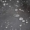 A close-up view of water droplets on a black fabric surface, likely demonstrating a waterproof material. Produktbild-Vorschau