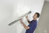 A man is plastering a wall with a trowel. Produktbild-Vorschau