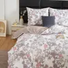 A neatly made bed with floral patterned bedding and decorative pillows. Podgląd zdjęcia produktu