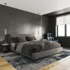 A modern bedroom with a bed, chair, and pendant lights. Produktbild-Vorschau