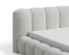 A close-up view of a bed frame with a textured fabric headboard and a mattress. Voir les images du produit