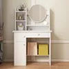 A white vanity table with a round mirror, shelves, and drawers, decorated with a few items. Podgląd zdjęcia produktu
