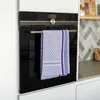 A blue checkered kitchen towel hangs on a towel rack attached to a modern oven. Produktbild-Vorschau