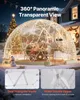 A transparent geodesic dome tent set up in a snowy yard at night, decorated with Christmas lights and a Christmas tree in the background. Anteprima dell’immagine prodotto