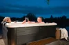 A couple enjoying a hot tub at dusk. Produktbild-Vorschau