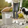 A person is feeding a dog from a container of dog food. Produktbild-Vorschau