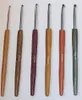 A set of six crochet hooks with wooden handles of different colors and sizes, laid out in a row against a white background. Produktbild-Vorschau