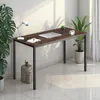 A desk with a laptop, notebook, lamp, and plants in a room. Voir les images du produit