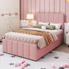 A pink upholstered bed with storage drawers in a bedroom setting, featuring a nightstand with a lamp and a wardrobe in the background. Podgląd zdjęcia produktu