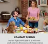 A family is gathered around a dining table, with a woman presenting a roasted chicken. Produktbild-Vorschau