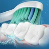A close-up of a toothbrush head cleaning teeth, with water droplets. Produktbild-Vorschau
