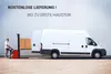 A forklift is loading boxes onto a white delivery van. The scene is set against a large, light-colored building. Produktbild-Vorschau