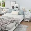 A bedroom scene with a bed, nightstands, and artwork. Voir les images du produit
