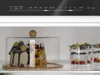 A refrigerator interior with a cake under a glass dome and fruit parfaits in glasses. Produktbild-Vorschau