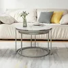 A set of two nesting coffee tables with marble-patterned tops and silver metal frames are placed in front of a sofa on a rug. Voir les images du produit