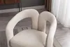 A close-up view of a beige velvet armchair in a room. Voir les images du produit