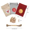 Three fabric bags with numbers and festive designs, a pile of wooden clothespins, and a spool of twine, all arranged on a white background with measurement indicators. Produktbild-Vorschau