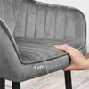 A hand is pressing down on the seat cushion of a gray velvet chair, with a ruler graphic indicating a measurement of 7 cm. Produktbild-Vorschau
