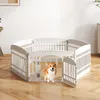 A white plastic dog playpen is set up on a wooden floor in a room with white walls. A corgi dog is standing inside the playpen, looking at the camera. Produktbild-Vorschau