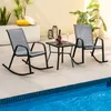 Two rocking chairs and a small table are set up on a patio next to a swimming pool. Náhled obrázku produktu