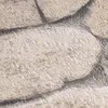 A close-up view of a textured wallpaper with a stone or brick pattern. Produktbild-Vorschau