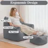 A woman sits in a large gray beanbag chair with an ottoman, holding a mug. Text overlays highlight ergonomic features. Náhľad obrázku produktu
