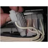 A close-up view of a hand holding a white plastic connector with several white tubes attached, possibly part of a printer's ink system. Produktbild-Vorschau