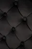 A close-up view of black tufted upholstery with buttons. Podgląd zdjęcia produktu