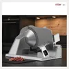 A silver meat slicer is shown on a dark countertop in a kitchen setting. Anteprima dell’immagine prodotto
