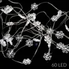A close-up view of a string of snowflake-shaped LED lights against a black background. Podgląd zdjęcia produktu