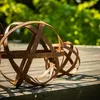 Two rusty garden spheres are placed on a wooden deck with a blurred green background. Voir les images du produit