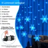 A close-up of blue snowflake string lights with a hand pressing a button on the power adapter, and text describing light modes and timer functions. Náhled obrázku produktu