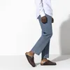 A person wearing Birkenstock clogs and jeans against a white background. Produktbild-Vorschau