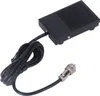 A black foot pedal switch with a coiled black cable and a silver connector is shown against a white background. Náhled obrázku produktu
