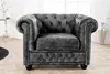 A dark gray Chesterfield armchair is shown in a well-lit room with a wooden floor. Produktbild-Vorschau