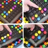 A collage of four close-up images showing a colorful ball game being played on a black board. Produktbild-Vorschau