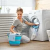 A woman is doing laundry in a bright, modern laundry room. Náhľad obrázku produktu