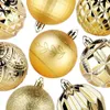 A collection of gold Christmas ornaments arranged on a white background. Náhled obrázku produktu