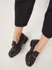 A pair of black women's loafers with a chunky sole, worn by a person. Anteprima dell’immagine prodotto
