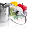 A stainless steel pot lid is shown partially open, with various colorful bell peppers and a red onion in the background. Voir les images du produit