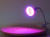 A clip-on LED grow light is positioned over a wooden surface, casting a purple glow. Anteprima dell’immagine prodotto