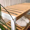A shoe rack with white shoes on it, placed against a white wall. Podgląd zdjęcia produktu