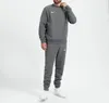 A man wearing a grey Nike tracksuit against a white background. Produktbild-Vorschau