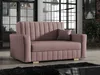 A pink sofa with a pillow is shown in a living room setting with large windows and a brick wall in the background. Náhled obrázku produktu