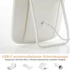Close-up of the back of a white LED makeup mirror, showing the USB-C charging port and a cable plugged in. Text below describes features and accessories. Produktbild-Vorschau