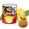 A can of mango puree and a glass of mango dessert are shown, along with a sliced mango and leaves. Produktbild-Vorschau