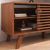 A close-up of a wooden TV stand with sliding doors and shelves. It has a mid-century modern design with tapered legs. Produktbild-Vorschau