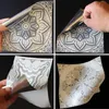 A collage of four images showing a person peeling off a protective film from a decorative tile sticker. Produktbild-Vorschau