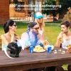 People gathered around a table outdoors, with a fan on the table. Produktbild-Vorschau