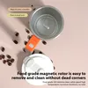 A self-stirring mug with its lid and magnetic rotor are shown, surrounded by coffee beans. Podgląd zdjęcia produktu